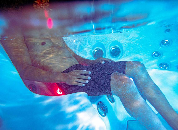 Relaxation d'un homme dans un spa moderne avec hydromassage et lumière infrarouge thérapeutique