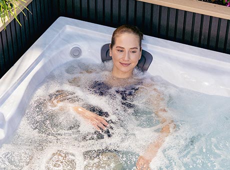 femme profitant d’un hydromassage dans un spa extérieur