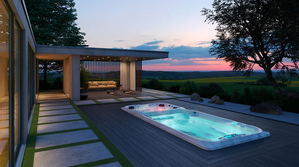 Spa de nage ou piscine : quel équipement choisir pour nager à domicile ? Spa de nage extérieur installé sur une terrasse contemporaine au coucher du soleil